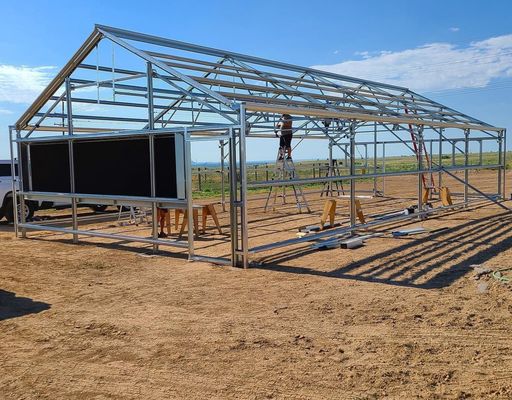 Estufa comercial de várias faixas com vista floral final e terraço de vidro listrado
